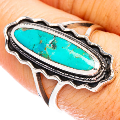 Sterling silver turquoise ring with long oval stone, scalloped frame, on finger
