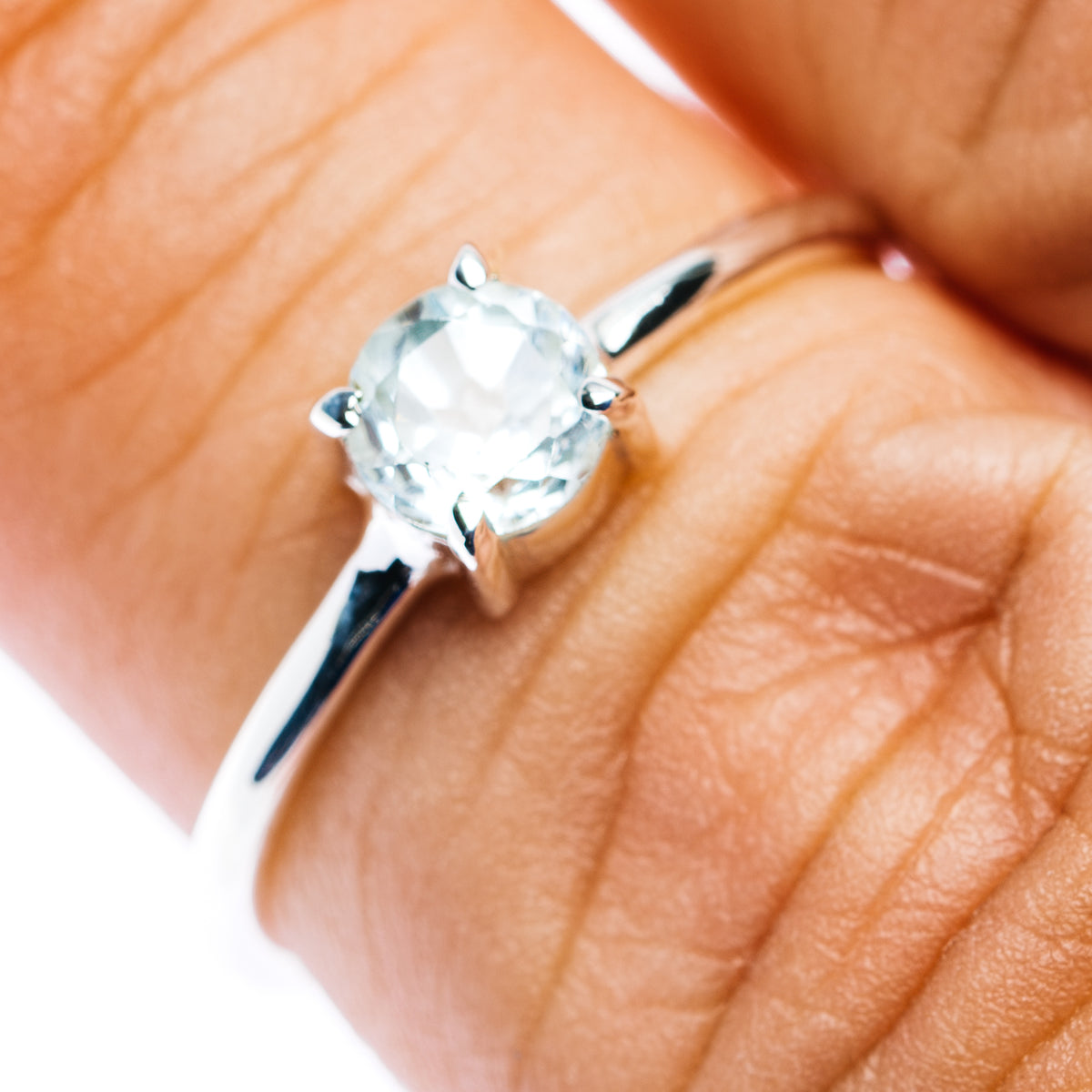 Sterling silver stackable ring with light blue round gemstone and prong setting