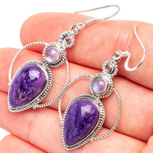Sterling silver dangle earrings with purple teardrop stones and round opalescent accents