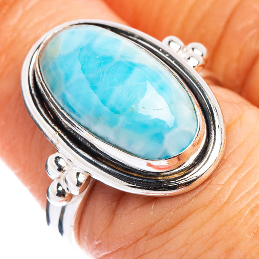 Close-up sterling silver ring with oval blue-green gemstone bezel settings