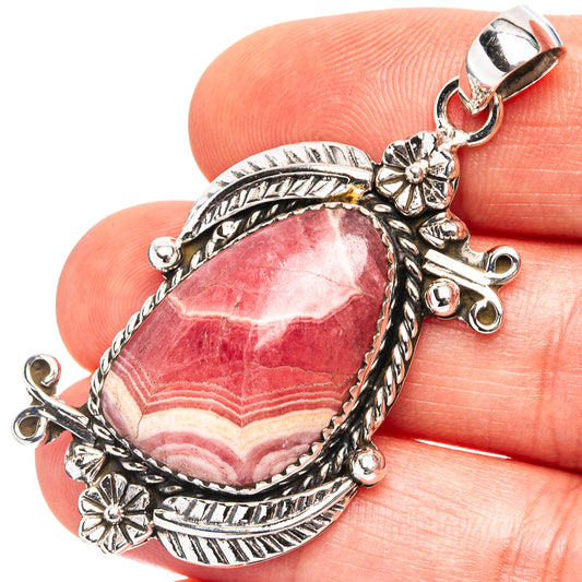 Oval rhodochrosite cabochon pendant in .925 sterling silver with ornate carved frame