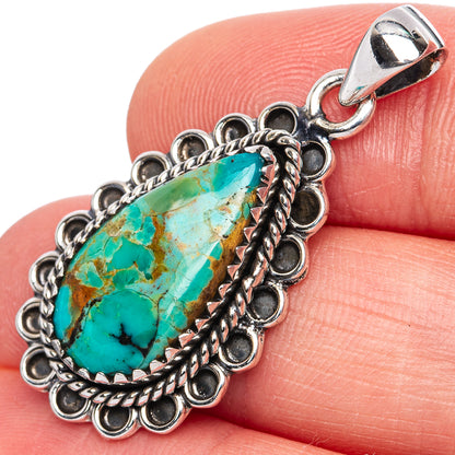 Turquoise teardrop pendant in ornate sterling silver setting, on silver bail