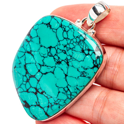 Turquoise teardrop pendant with black webbed pattern, silver frame and top bail