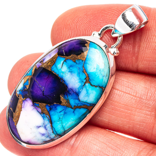 Oval turquoise-and-purple stone pendant in sterling silver, shown on fingertip