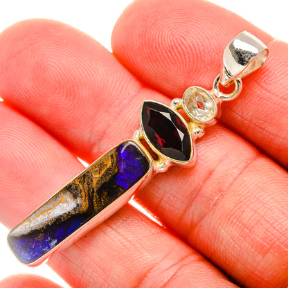 Sterling silver pendant with blue boulder opal bar, red and clear stones, bail top