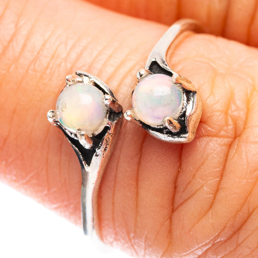 Sterling silver opal ring with round Ethiopian opal bezel, prong-set on finger close-up