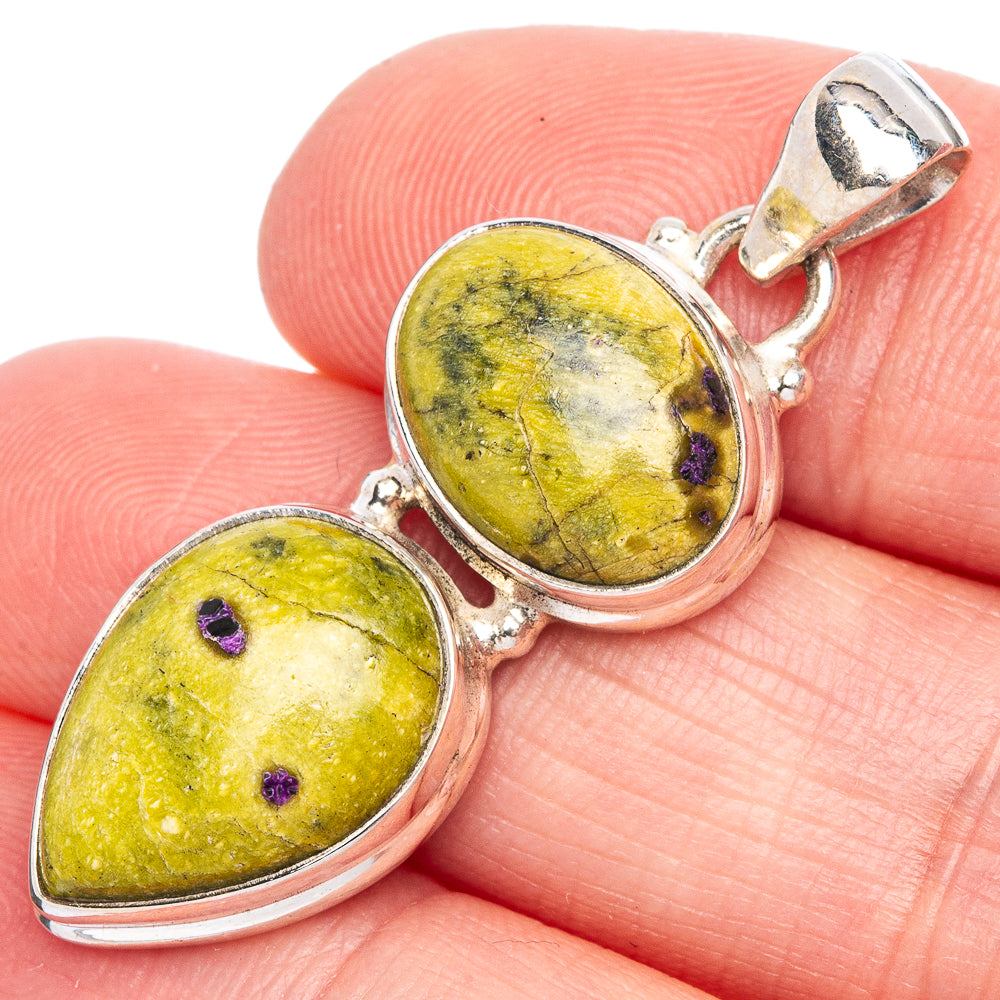 Sterling silver pendant with two oval yellow-green gemstones, purple specks, bail top