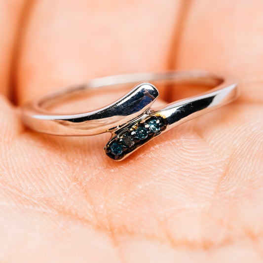 Sterling silver ring with blue gemstone row, angled view on finger