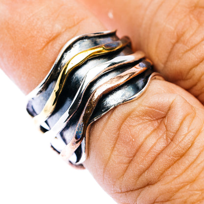 Meditation spinner ring, brushed sterling silver with gold accents on finger