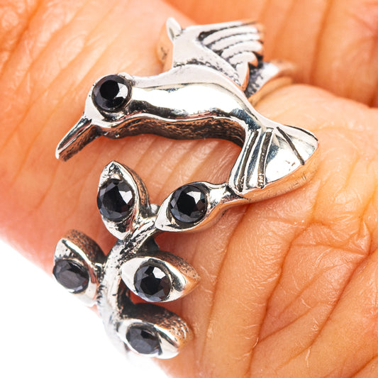 Sterling silver hummingbird dainty ring with black onyx-style stones, close-up on hand