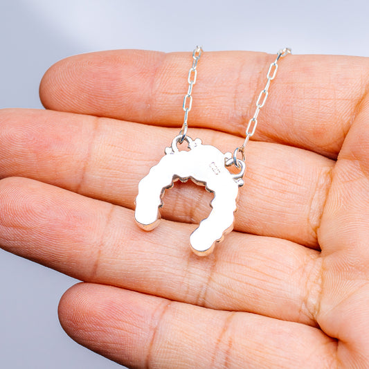 Sterling silver turquoise pendant necklace with cutout horseshoe-like charm on chain