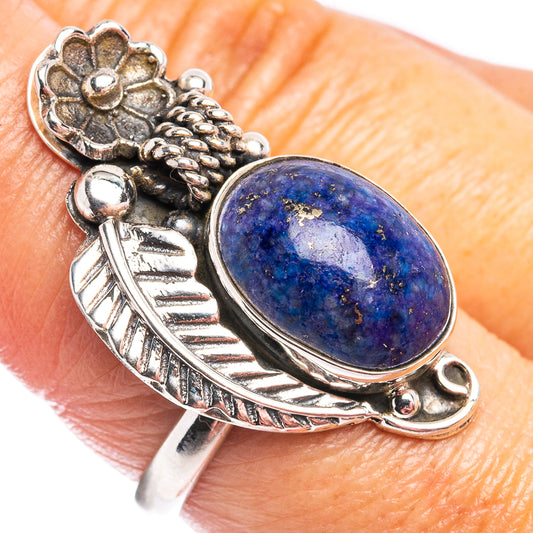 Sterling silver ring on finger with oval blue sodalite cabochon and detailed floral accents