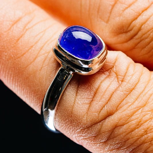 Oval blue-violet gemstone tanzanite ring in polished sterling silver, close-up on top