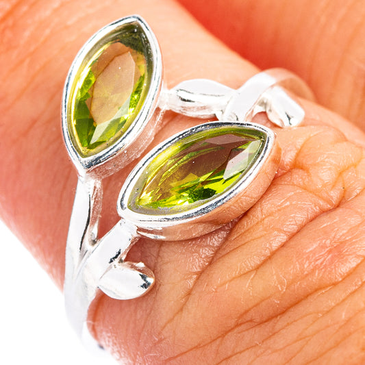 Sterling silver peridot leaf dainty ring with two green teardrop stones on finger
