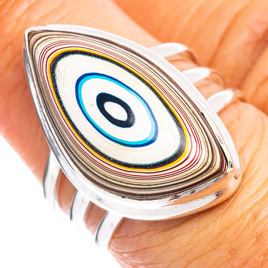 Sterling silver oval ring with striped multicolor fordite inlay and blue teardrop center.