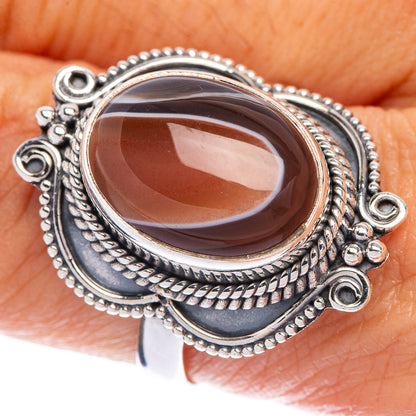 Sterling silver ring with oval brown Botswana agate and ornate rope bezel setting