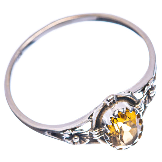 Sterling silver ring with prong-set oval yellow gemstone and carved shoulders