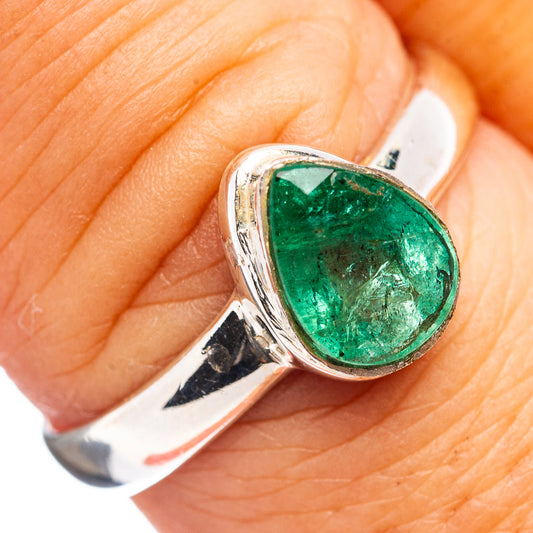 Sterling silver emerald ring with teardrop green gemstone, close-up on finger