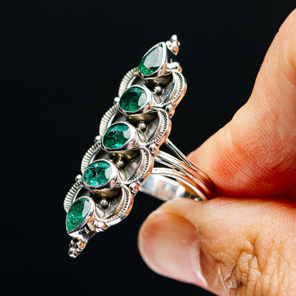 Sterling silver ring with five oval green gemstones, side view on finger