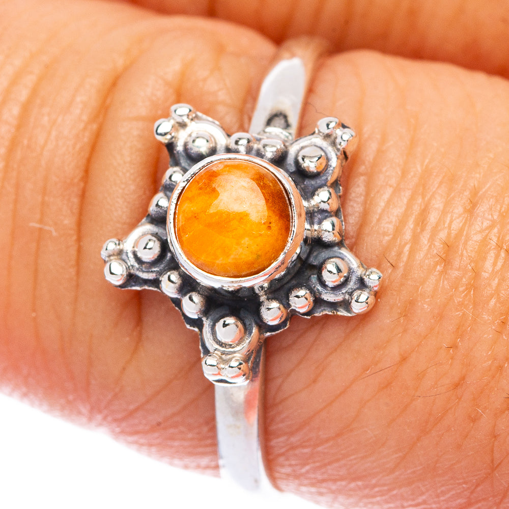 Silver dainty ring with ornate bezel and round orange cabochon stone
