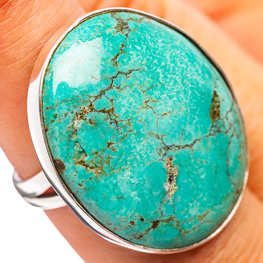Oval turquoise cabochon ring with sterling silver bezel, close-up on finger