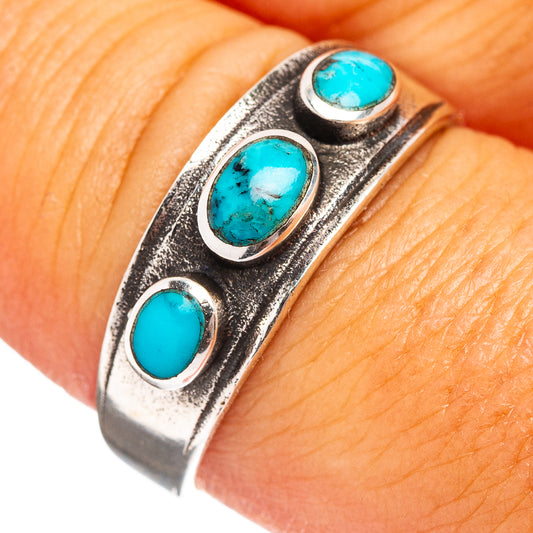 Turquoise inlay sterling silver ring with three oval stones, close-up on finger