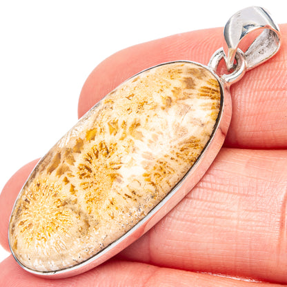 Sterling silver oval coral pendant with textured beige-and-gold stone and bail, close-up