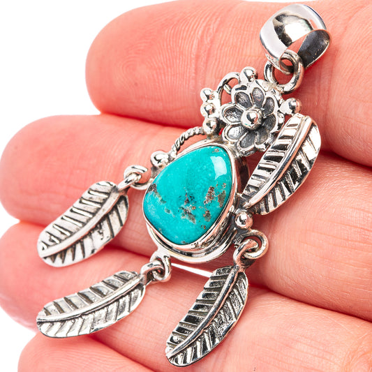 Turquoise oval cabochon pendant in sterling silver, close-up with feather and flower charms