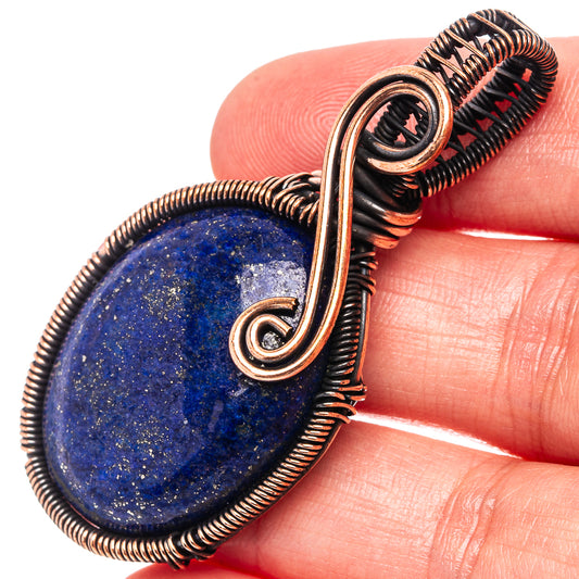 Lapis lazuli oval pendant wire-wrapped in oxidized copper, close-up looped bail