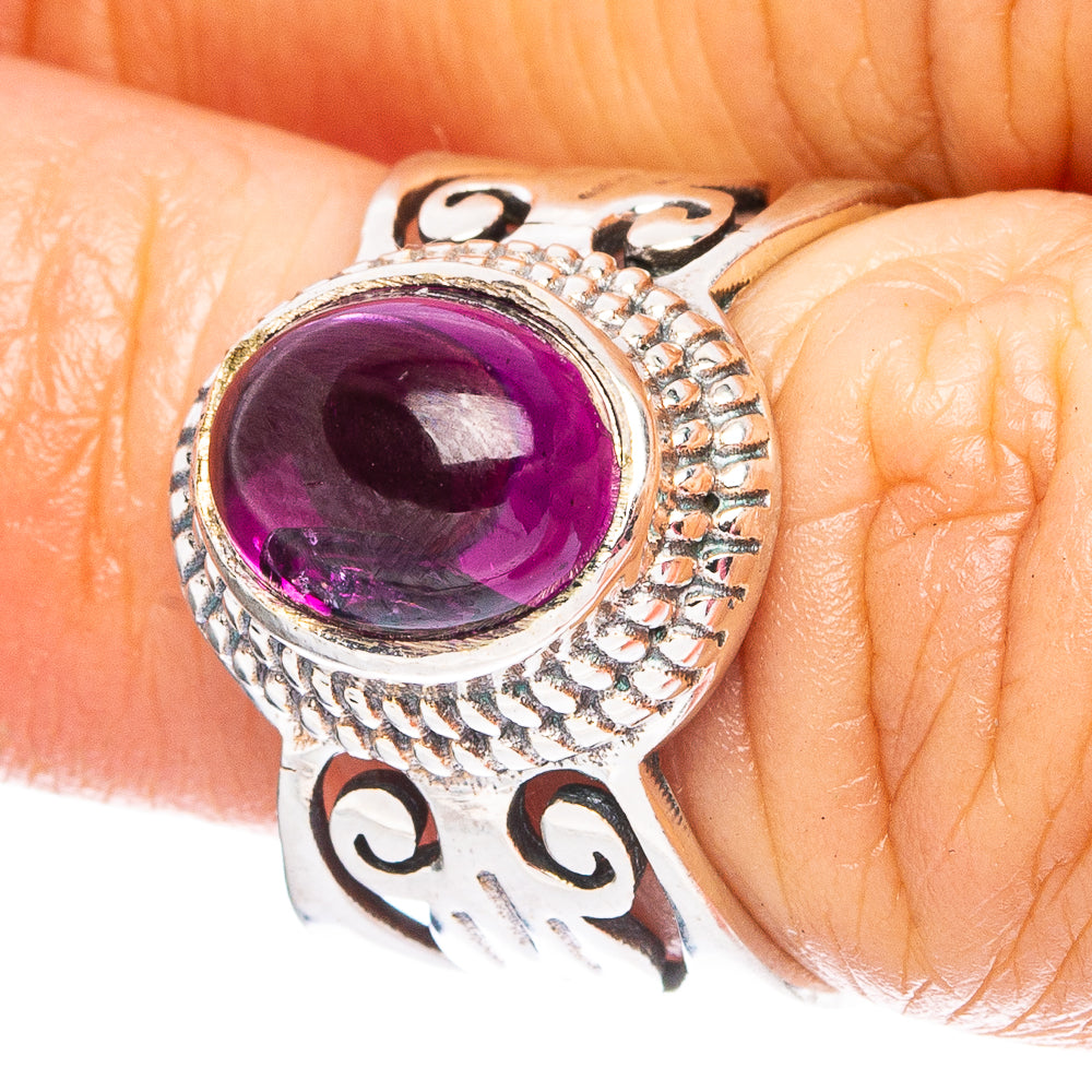 Sterling silver ring with oval purple gemstone bezel and ornate side detailing