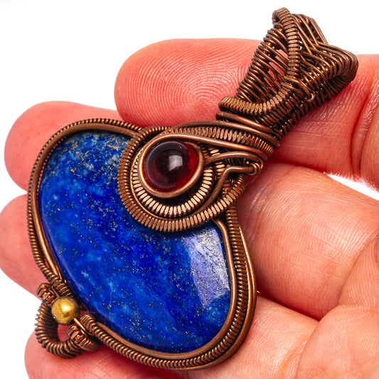 Close-up oxidized copper wire-wrap pendant with blue lapis teardrop and dark red center stone