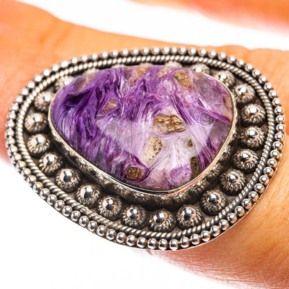 Sterling silver ring with oval purple charoite cabochon and beaded halo bezel