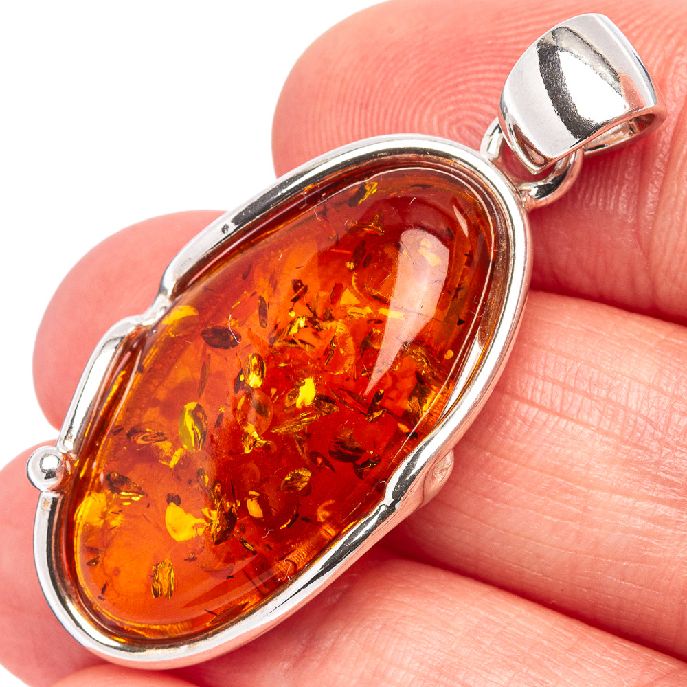 Oval amber pendant in .925 sterling silver bezel with warm orange Baltic amber cabochon.