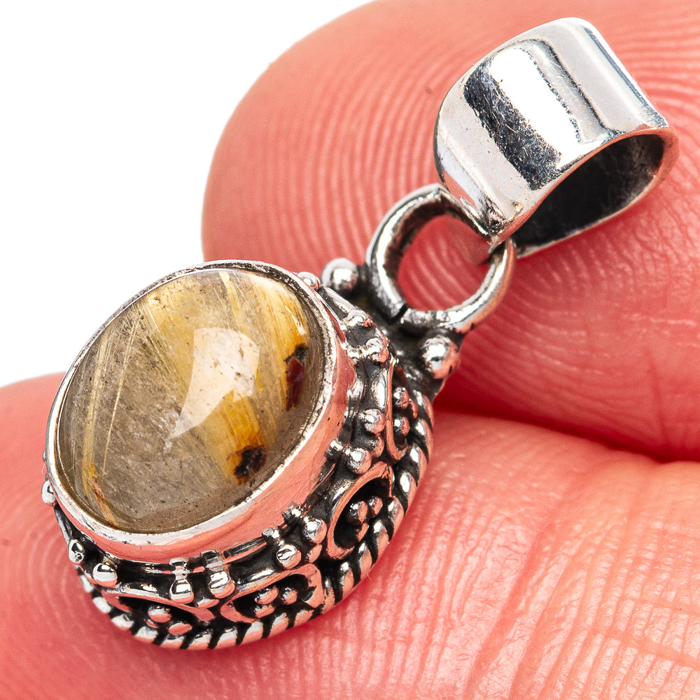 Rutilated quartz pendant viewed close-up; silver bail and textured bezel detail