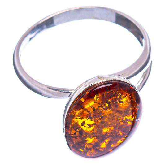 Silver adjustable ring with oval Baltic amber cabochon set in a round bezel.