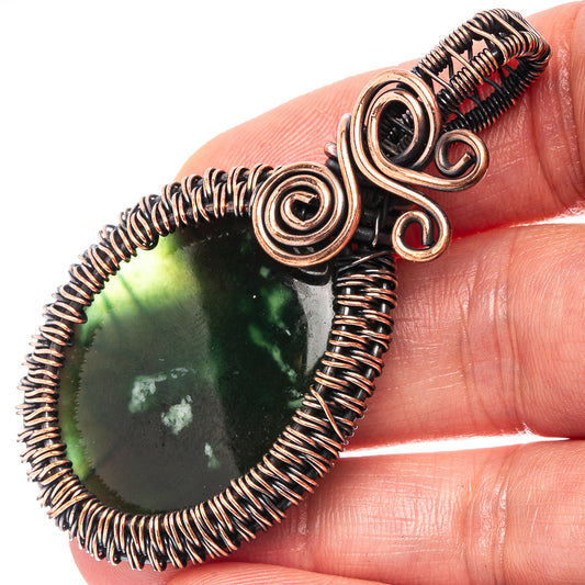 Oxidized copper wire-wrap pendant with dark green teardrop gemstone, close-up bail