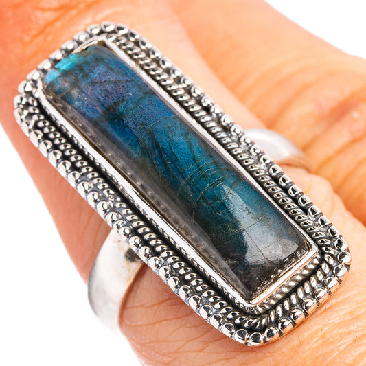 Rectangular labradorite ring on finger, sterling silver rope bezel with blue iridescent stone