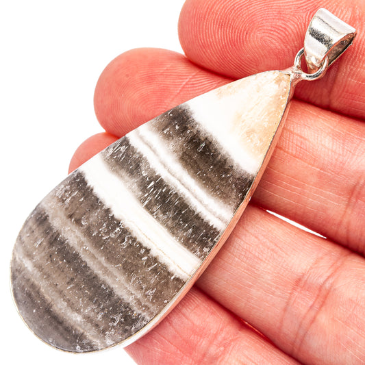 Silver-plated zebra calcite pendant close-up: teardrop striped stone and bail