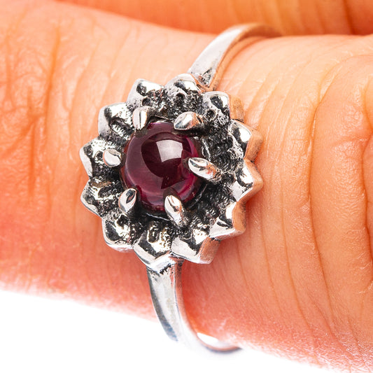 Sterling silver garnet ring with oval deep red center and halo of prong-set stones