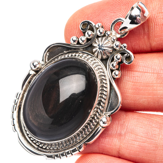 Sterling silver pendant with oval dark cabochon stone and ornate beaded halo frame