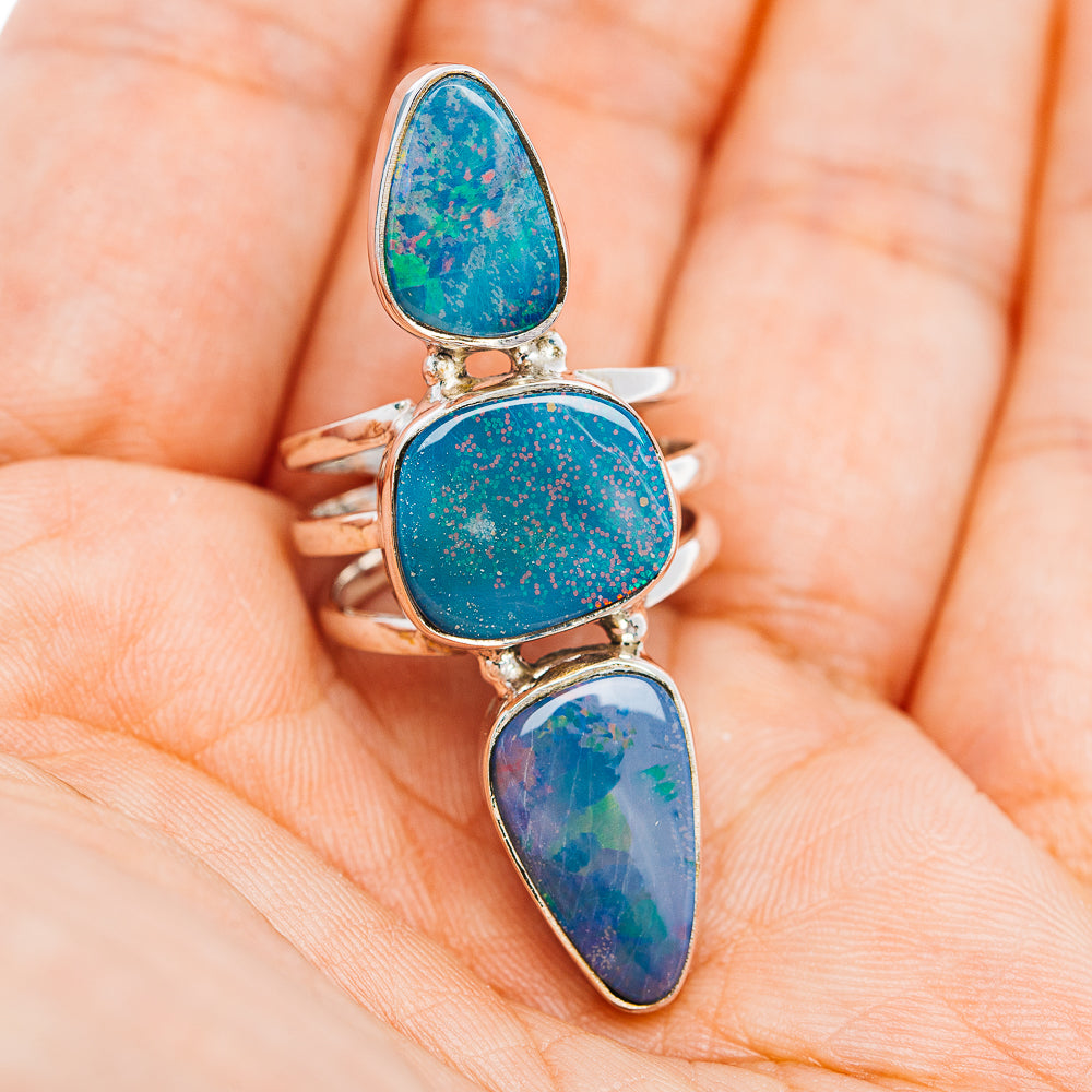 Sterling silver opal ring with three blue teardrop cabochons on hand, front view