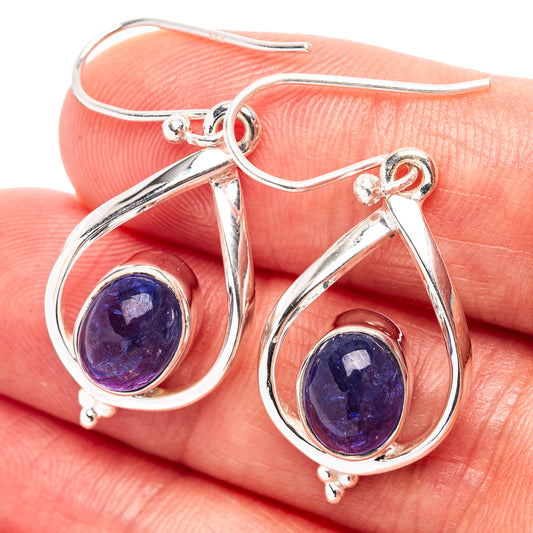 Sterling silver tanzanite teardrop earrings with purple oval cabochon and hook backs.