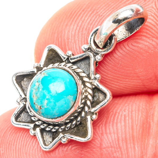 Turquoise pendant with oval stone in ornate silver star frame and hinged bail