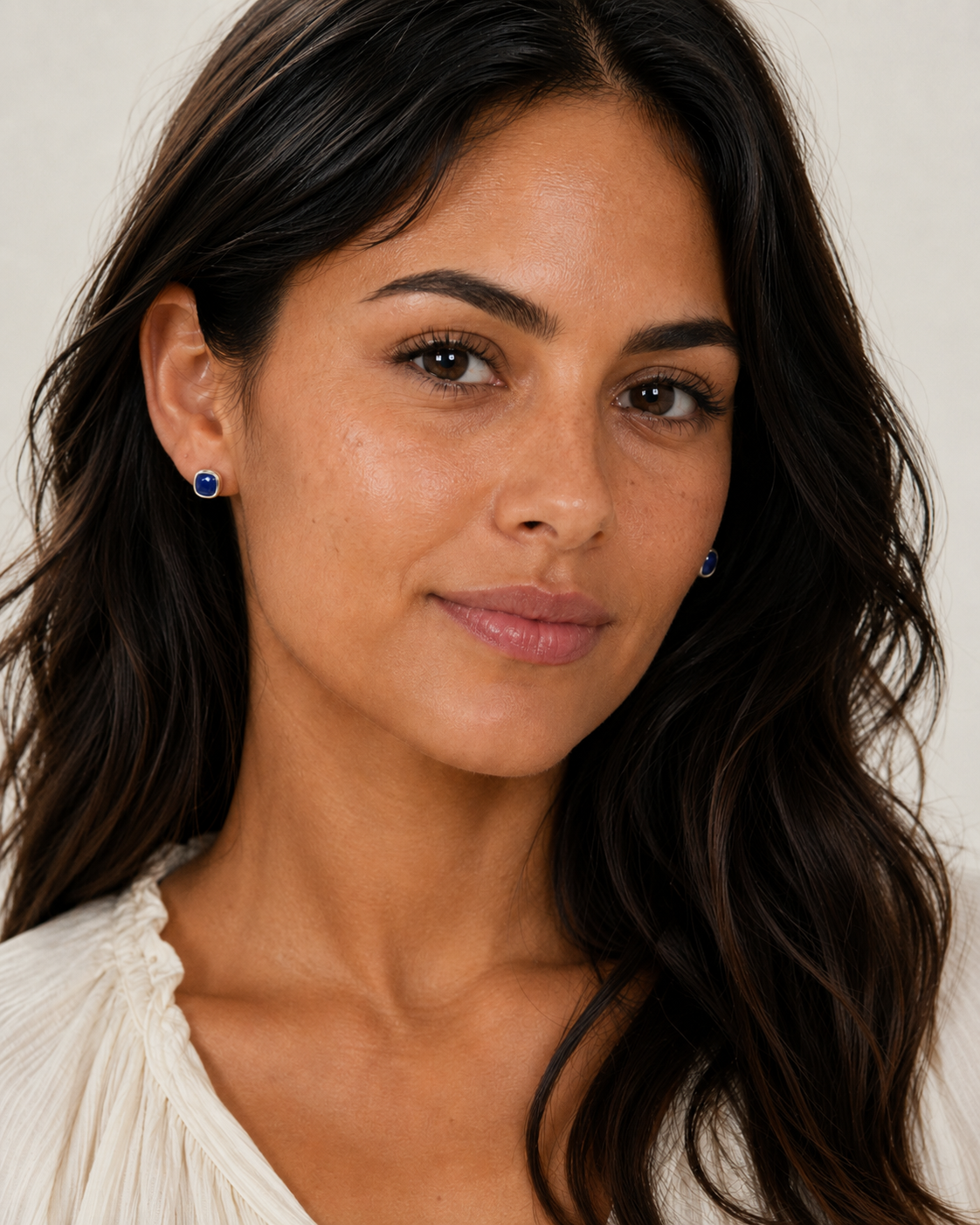 Blue tanzanite stud earrings on model, set in polished .925 sterling silver