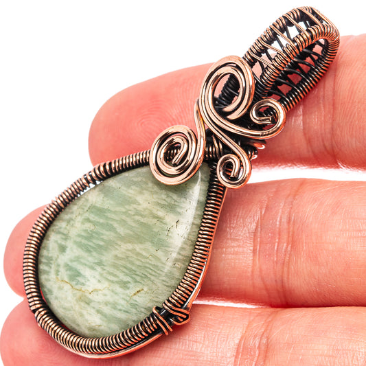 Wire-wrapped amazonite teardrop pendant close-up with oxidized copper coils