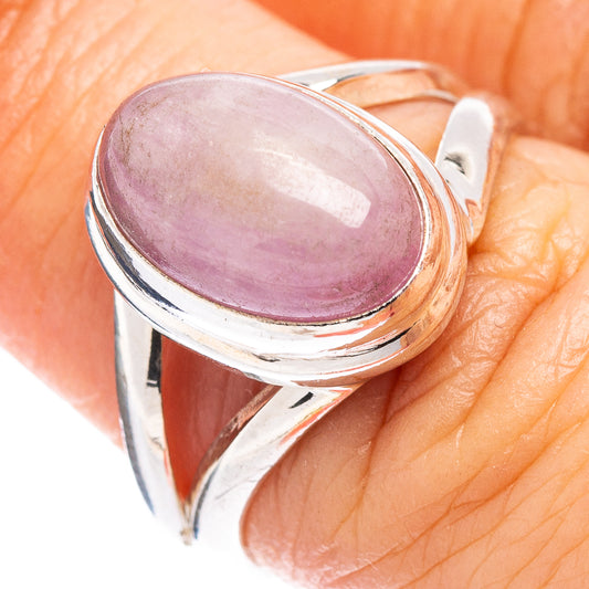 Sterling silver kunzite ring on finger, oval purple gemstone with metal bezel