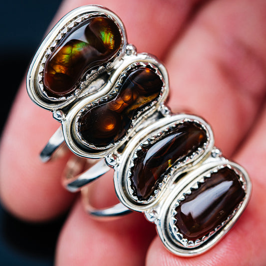 Silver ring featuring four oval cabochons with amber, green, and rainbow fire effects
