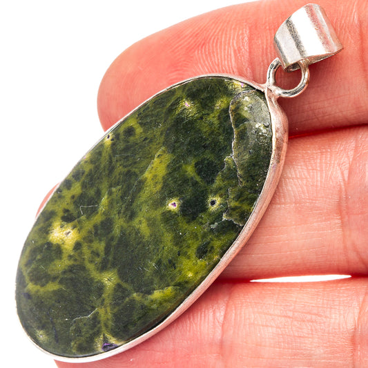 Stichtite pendant with oval green-yellow speckled stone, silver-plated bail and loop top