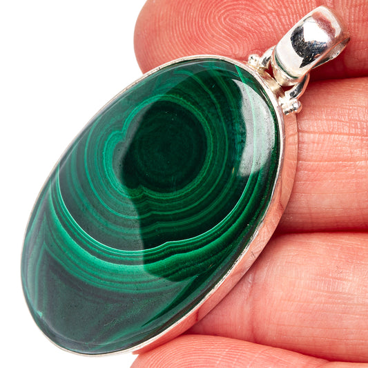 Oval malachite pendant close-up with swirling green stripes and silver top bail