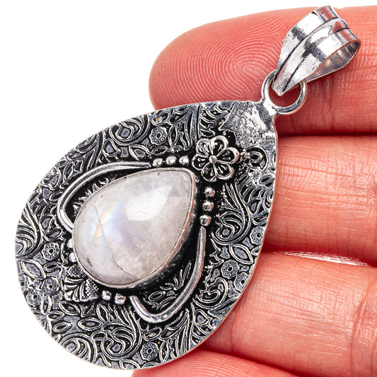 German silver moonstone teardrop pendant with ornate floral frame, oval rainbow stone